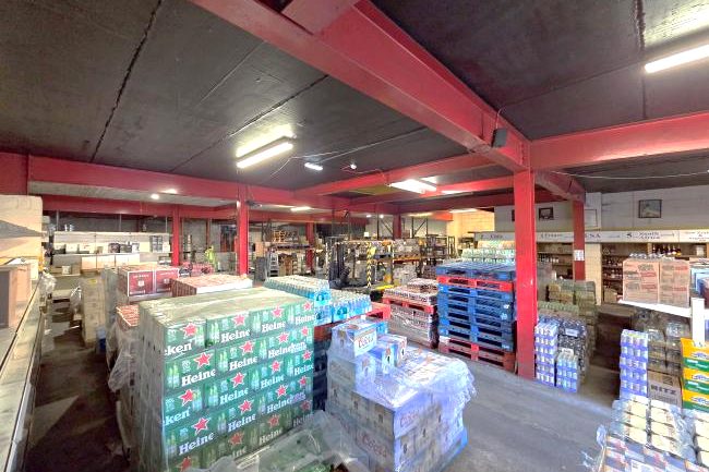 Inside Galvins cash & carry, Bandon Road, Cork: pallets of Heineken and other beer cases under the red steel beams